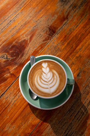 latte coffee cup with latte art on table view from top view.の写真素材