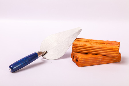 Trowel spade blue wood handle with two red bricksの写真素材