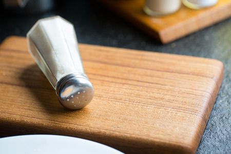 Salt shaker on wooden boardの写真素材