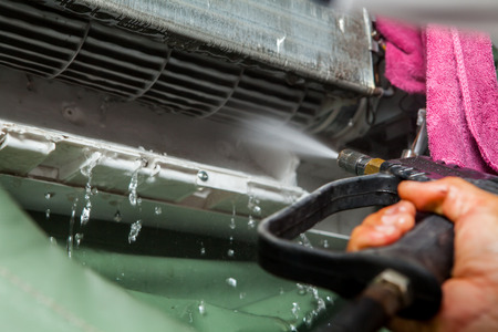 Repairman fixing and cleaning air conditioner unitの写真素材