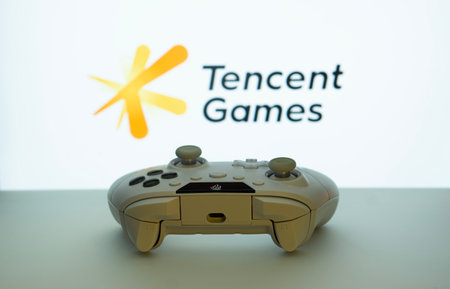 Dhaka, Bangladesh- 14 Nov 2025: A close-up of a white gamepad with the Tencent Games seen on screen...