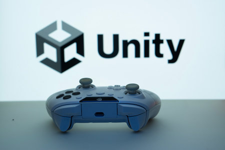 Dhaka, Bangladesh- 14 Nov 2025: A close-up of a white gamepad with the Unity seen on screen in the background.のeditorial素材