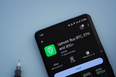 Dhaka, Bangladesh- 19 Sep 2025: On a blue surface, a smartphone displays the Uphold app within the Google Play Store.のeditorial素材