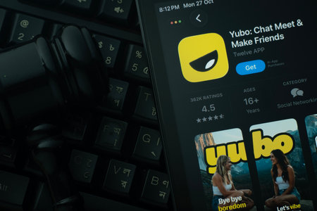 Dhaka, Bangladesh- 28 Oct 2025: An iPad displaying the Yubo app against a judge's gavel and dark keyboard background.のeditorial素材