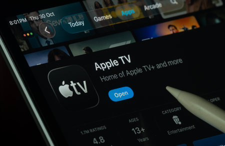 Dhaka, Bangladesh- 30 Oct 2025: Apple TV app displayed on a iPad screen in dark mode with a digital pen pointing at it.のeditorial素材