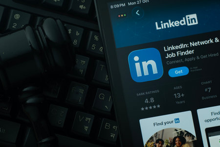 Dhaka, Bangladesh- 28 Oct 2025: An iPad displaying the LinkedIn app against a judge's gavel and dark...