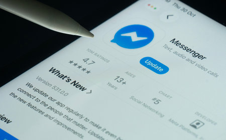 Dhaka, Bangladesh- 30 Oct 2025: Facebook Messenger app on a iPad screen with a pen pointing at the install option.のeditorial素材