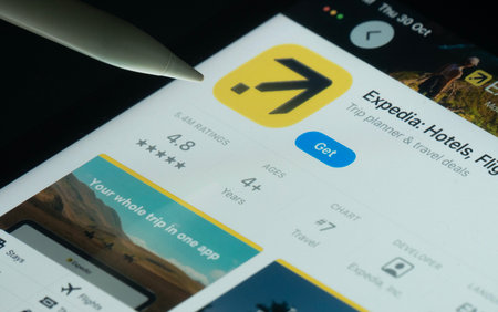 Dhaka, Bangladesh- 30 Oct 2025: Expedia app on a iPad screen with a pen pointing at the install option.のeditorial素材