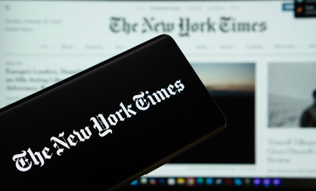 Dhaka, Bangladesh - 18 March 2025: The logo of the the new york times is displayed on a smartphone screen, and the website the new york times is visible on a computer screen in the background.のeditorial素材