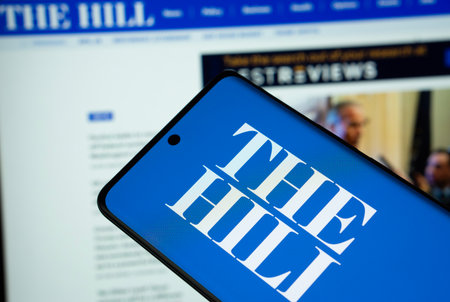 Dhaka, Bangladesh - 18 March 2025: The logo of The Hill is displayed on a smartphone screen, and the website is visible on a computer screen in the background.のeditorial素材