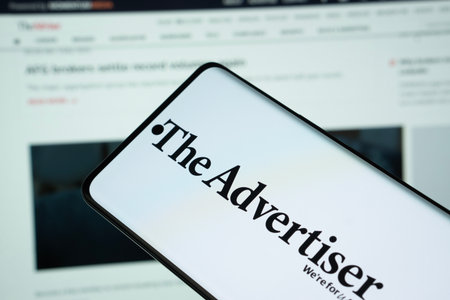 Dhaka, Bangladesh - 18 March 2025: The logo of the advertiser is displayed on a smartphone screen and the website is visible on a computer screen in the background.のeditorial素材