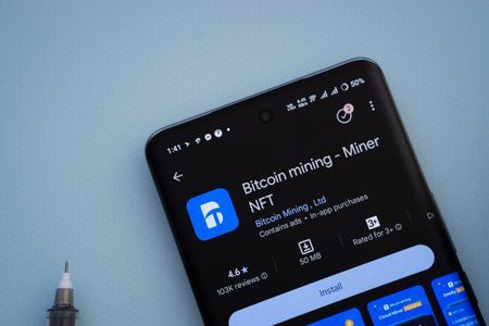 Dhaka, Bangladesh- 29 May 2025: On a blue surface, a smartphone displays the Bitcoin mining app...