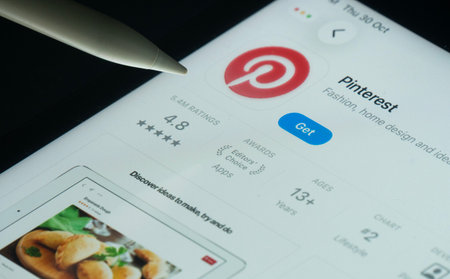 Dhaka, Bangladesh- 30 Oct 2025: Pinterest app on a iPad screen with a pen pointing at the install...