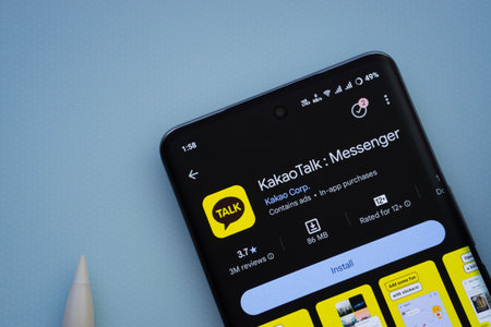 Dhaka, Bangladesh- 29 May 2025: On a blue surface, a smartphone displays the KakaoTalk app within...