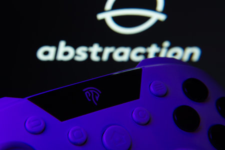 Dhaka, Bangladesh- 24 Mar 2025: A close-up of a gamepad with the Abstraction seen on screen in the background.のeditorial素材