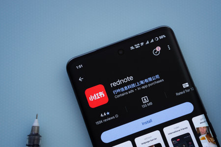 Dhaka, Bangladesh- 29 May 2025: On a blue surface, a smartphone displays the rednote app within the Google Play Store.のeditorial素材