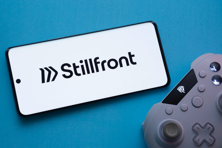 Dhaka, Bangladesh- 22 March 2025: Stillfront Group logo displayed on a smartphone surrounded by gaming accessories in an Blue background.