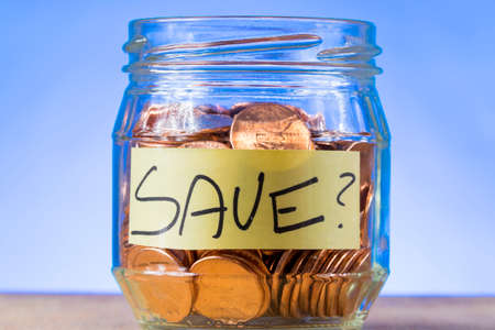 Why save? A shot of a small jar of American pennies with the word "Save" inside of it on a piece of paper.の写真素材