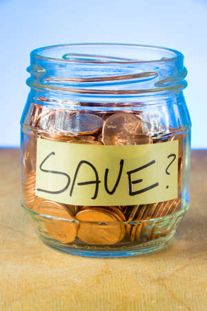 Why save? A shot of a small jar of American pennies with the word "Save" inside of it on a piece of paper. の写真素材