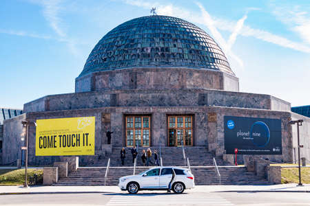 Chicago, IL, United States - March 12, 2017 - People walking out from The Adler Planetarium in Chicago, Illinois; Inifnniti SUV parked outside of The Adler Planetarium.のeditorial素材