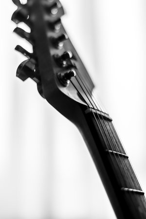 Monochrome fine art shot of an electric guitar on a very bright background.