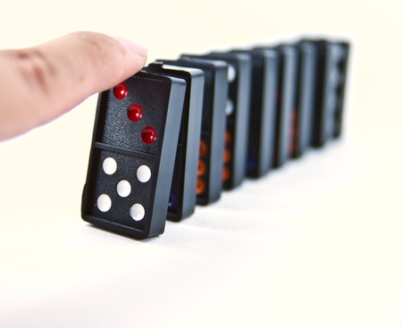 A finger ready to start domino chain reaction.の写真素材
