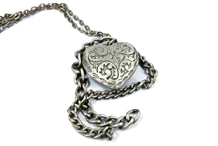 Old worn silver heart charm necklace.