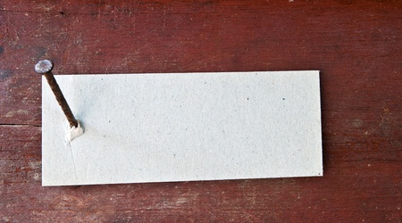 Paper label attached on wood wall with nailの写真素材