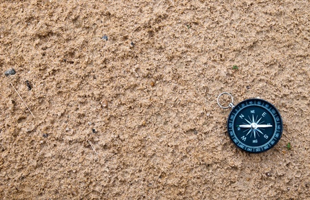 Compass lying on the sand の写真素材