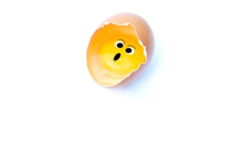 Surprise yolk from cracked eggの写真素材