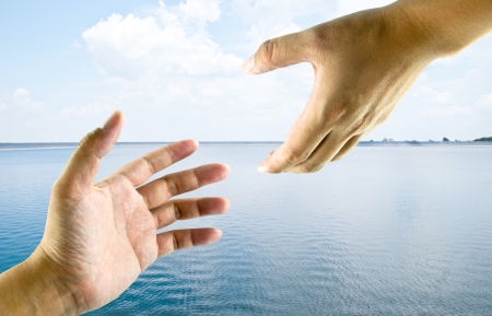 A hand help from another hand. This image ideas for a rescue, safety, religious or support concept. のeditorial素材