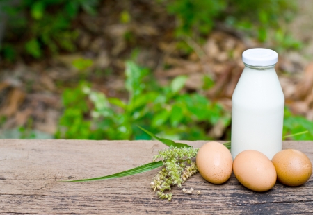Brown eggs and milk on wooden background の写真素材
