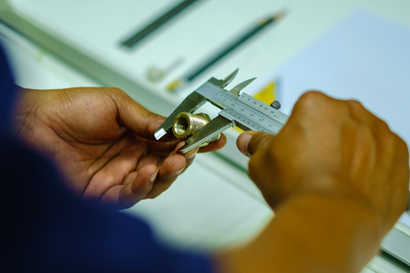 Man's hands using Vernier caliper to measure the objectの写真素材