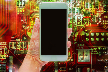 Double exposure of hand holding mobile smartphone and electronic circuit board, communication technology conceptの写真素材