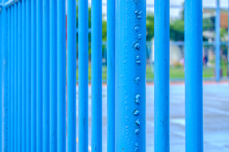 Blue steel fence around soccer field with rough surface texturedの写真素材