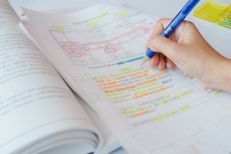 Tutorial document sheet and book for an examination with blurred highlight color and Thai text.の写真素材