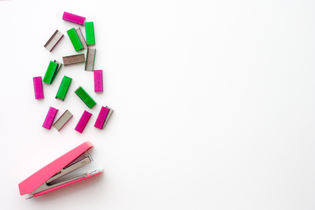 Top view of office accessories, pink stapler and colorful of staples with space for your design...