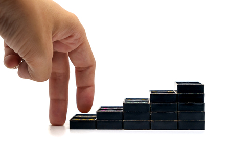 Fingers moving step up the black domino staircase on white background, business and growth conceptの写真素材