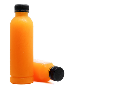 Bottles of fresh orange juice on white background with copy space, healthy drinking conceptの写真素材