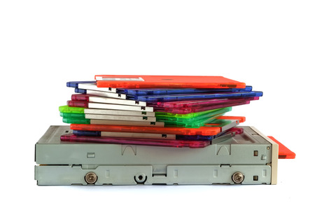 Floppy disk drive and diskettes on white background, old technology and legacy industrial computer...