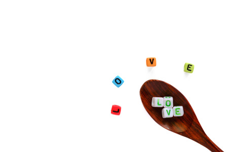 LOVE word from alphabet letter bead on wooden spoon and spreading out on white background with copy space for Valentine's day and love conceptの写真素材