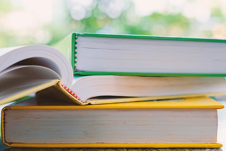 Stack of book on blurred natural green background and added colour filter for education and learning...
