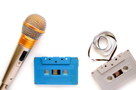 Microphone and retro cassette tape on white background for entertainment concept