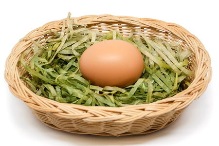 Egg in the wicker basket on white background for healthy food conceptの写真素材