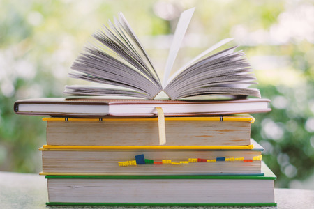 Stack of book on blurred natural green background with soft tone effect for knowledge and education conceptの写真素材