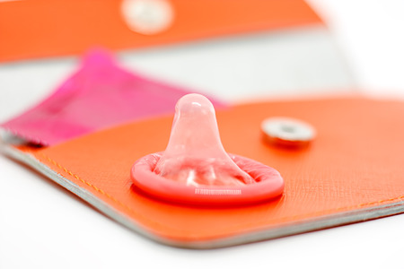 Male condom on orange bag for contraception and safety sex conceptの写真素材