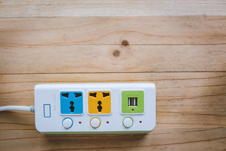 Extension socket on wooden background for electric appliance conceptの写真素材