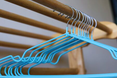 Empty clothes hangers on wooden rack for household items.の写真素材