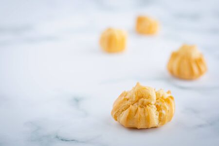 Delicious eclair vanilla cream, choux dough filled with a cream, homemade bakery on white marble background for snack eating conceptの写真素材