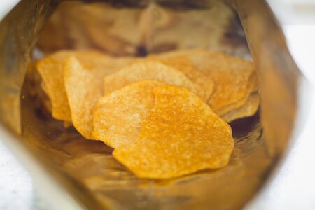 Close up of baked potato chips in opened snack bag for food conceptの写真素材